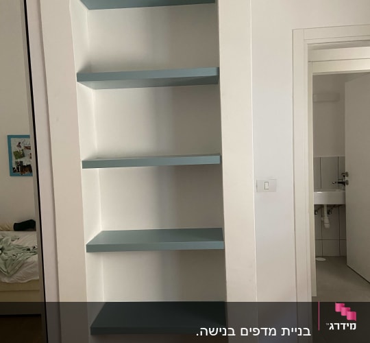 מדפים כחולים מותקנים בקיר לבן